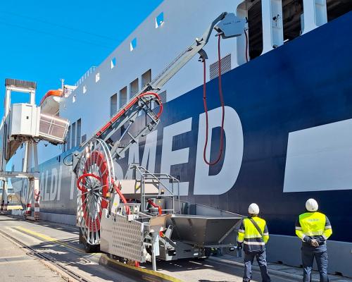 Two operators check the OPS cabling management system to ensure the connection to the ship.